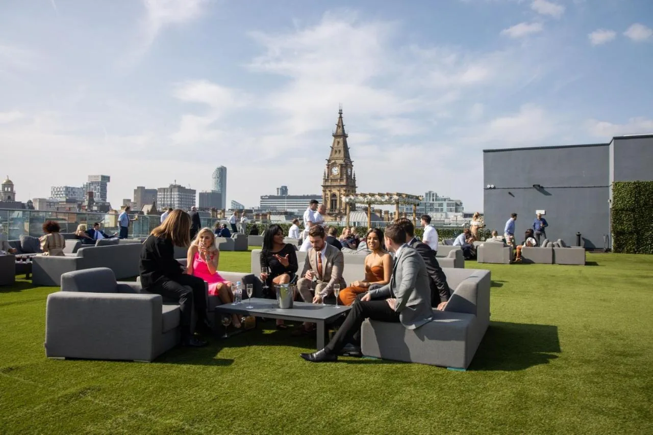 a group of people sitting on couches in the grass at The Shankly Hotel in Liverpool