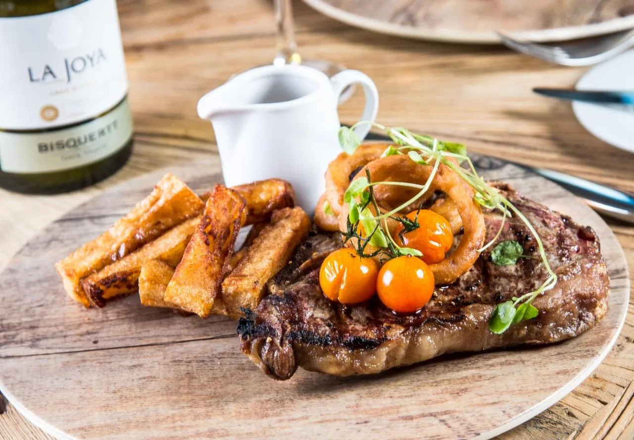 a plate of food with a steak and french fries at The Shankly Hotel in Liverpool