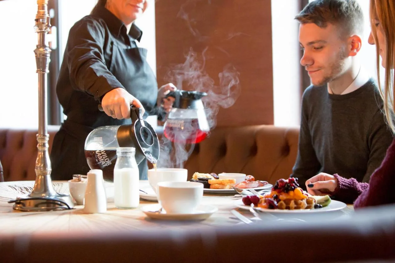 a man sitting at a table with a plate of food at The Shankly Hotel in Liverpool